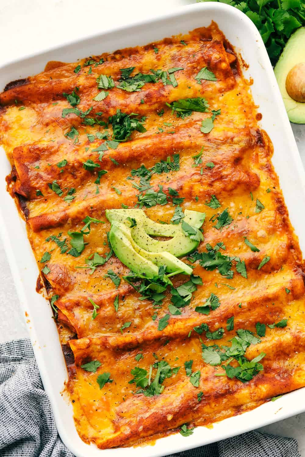 Chicken Enchiladas are saucy, cheesy and super scrumptious. These are made with my Enchilada sauce, which makes them even better than store bought! A pan of cheesy chicken enchiladas.