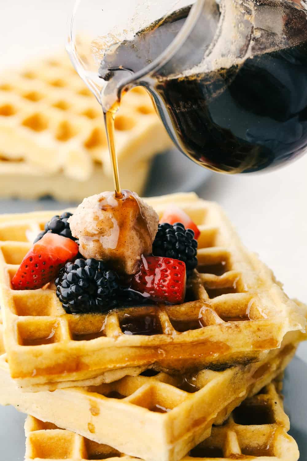 Homemade Maple Syrup is super easy and way better than store bought! Making your own syrup is going to change the way you do breakfast! Pouring maple syrup over waffles.