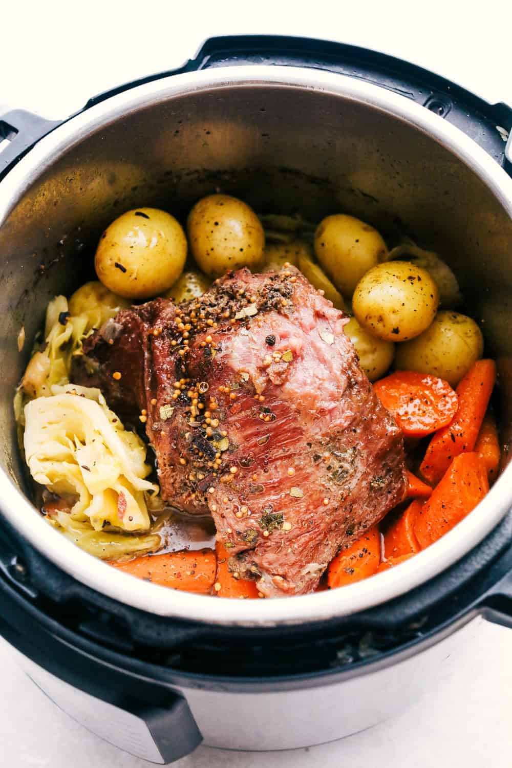 Instant Pot Corned Beef and Cabbage will make your St. Patrick's Day a breeze. The beef is tender and the cabbage and potatoes is full of flavor, you will love this! Cooked corned beef with cabbage, potatoes, and carrots.
