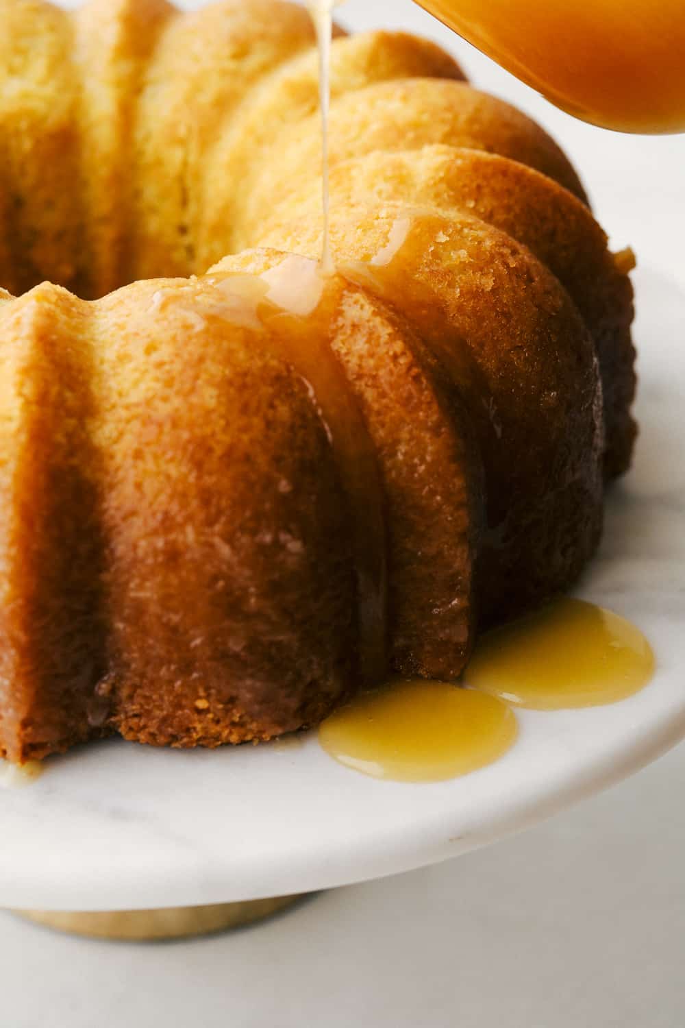 Kentucky Butter Cake is a moist, soft, buttery cake that is incredibly delicious. This luscious cake soaks up a buttery sweet sauce, that leaves a golden scrumptious crust you are going to love! Drizzling the sauce on top of the cake.