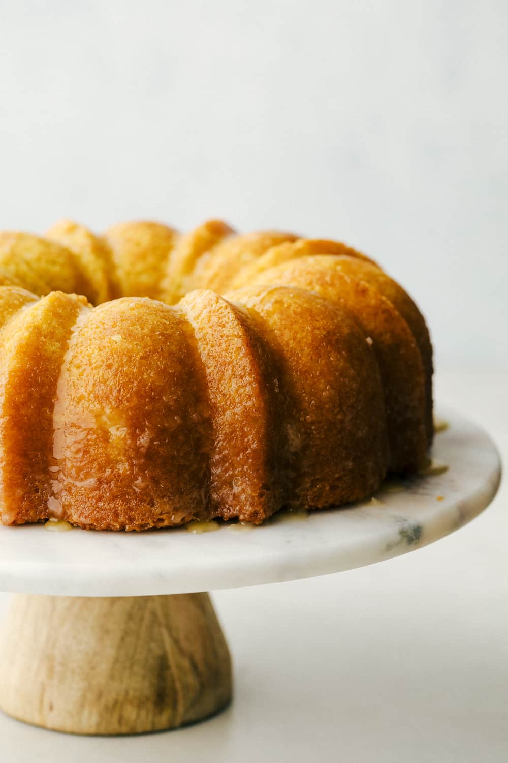 Kentucky Butter Cake is a moist, soft, buttery cake that is incredibly delicious. This luscious cake soaks up a buttery sweet sauce, that leaves a golden scrumptious crust you are going to love! Up close picture of cake on a platter.