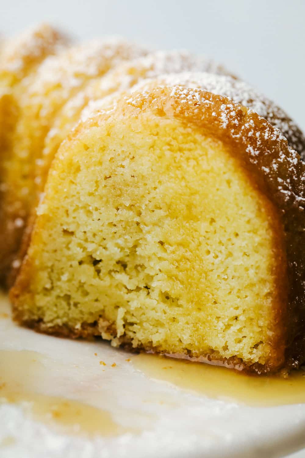 Kentucky Butter Cake is a moist, soft, buttery cake that is incredibly delicious. This luscious cake soaks up a buttery sweet sauce, that leaves a golden scrumptious crust you are going to love! Up close picture of cake with the drizzle soaked into the cake.