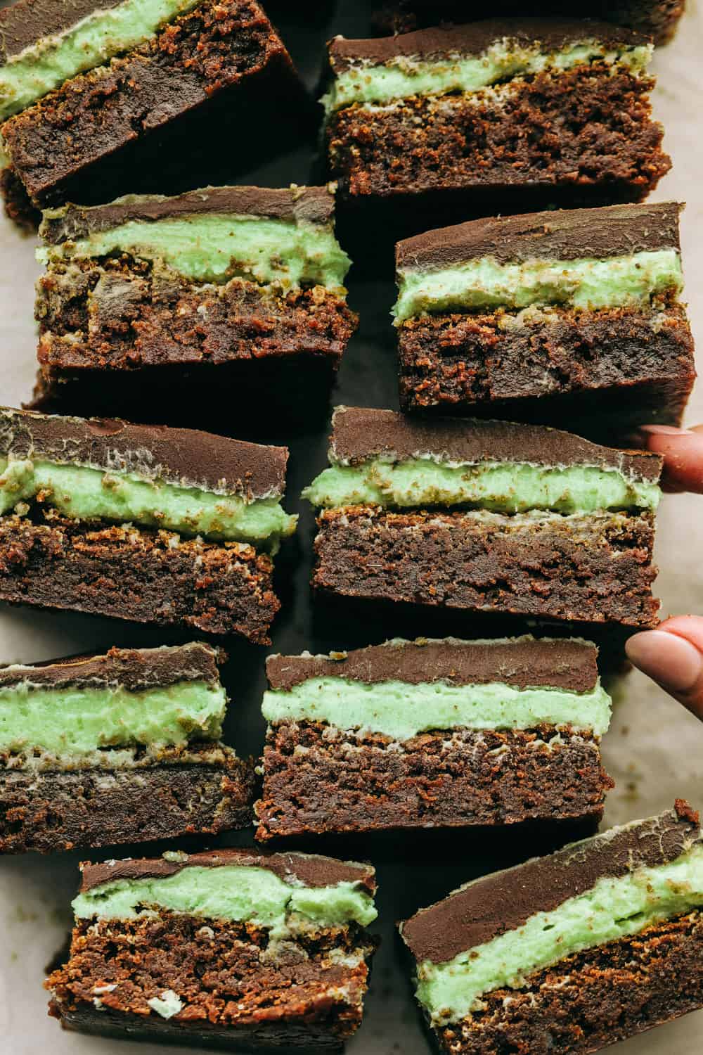 These are the Absolute Best Mint Brownies Ever! They have a thick fudgy brownie bottom, soft mint middle and a smooth, melt in your mouth ganache top! Mint brownies on their sides showing the layers.