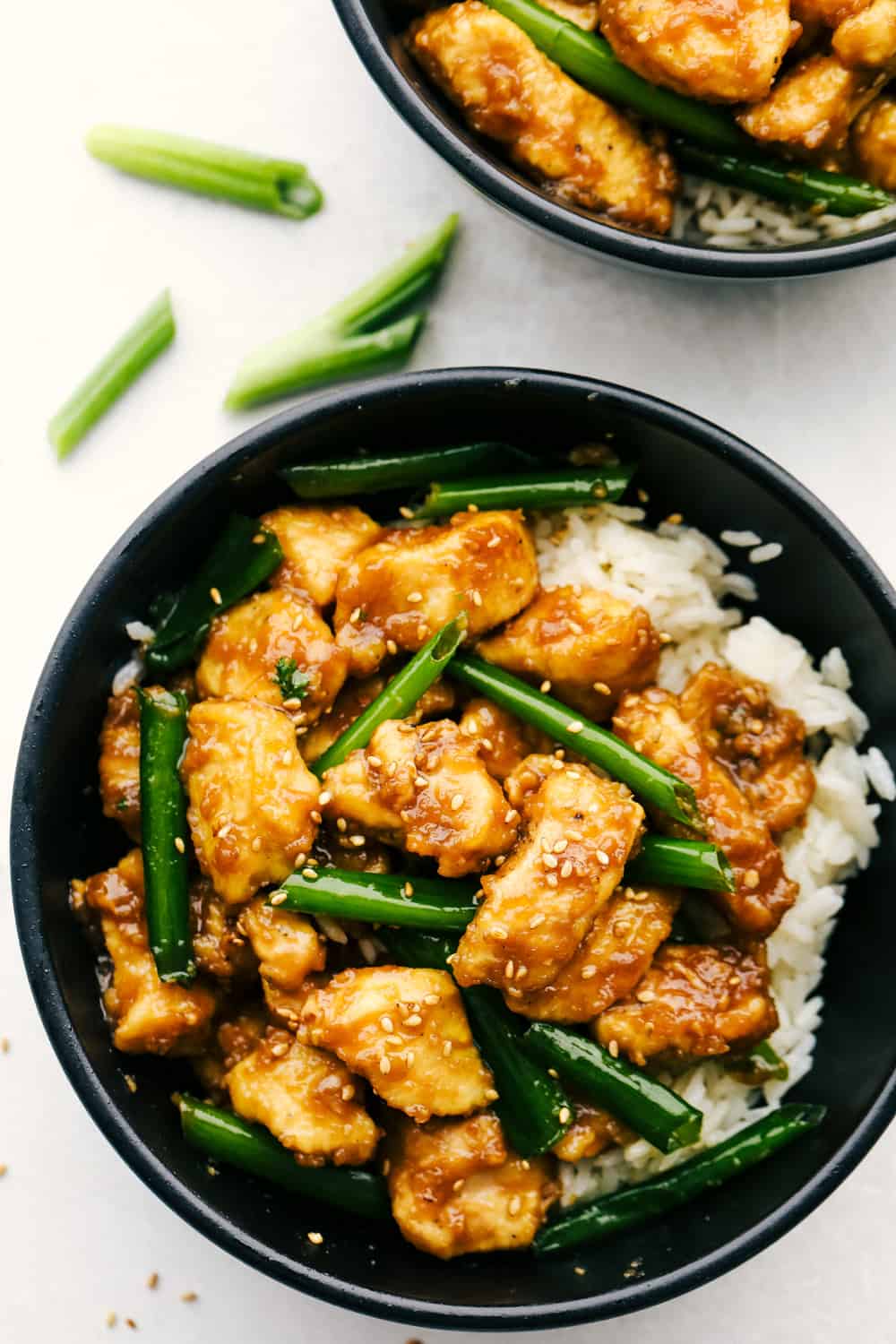 Mongolian Chicken is coated chicken tossed in a sweet savory sauce that is better than take out!ย This simple recipe is the beginning to tasty dinner in minutes. Mongolian chicken in bowl with rice.