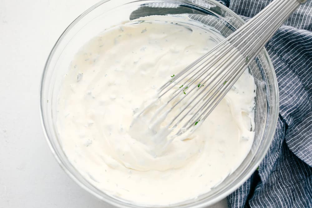 This Veggie Dip is easy, quick and the yummiest dip! This creamy, full of flavor dip is the perfect way to get your kids to eat their vegetables! Whisking the ingredients for vegetable dip.