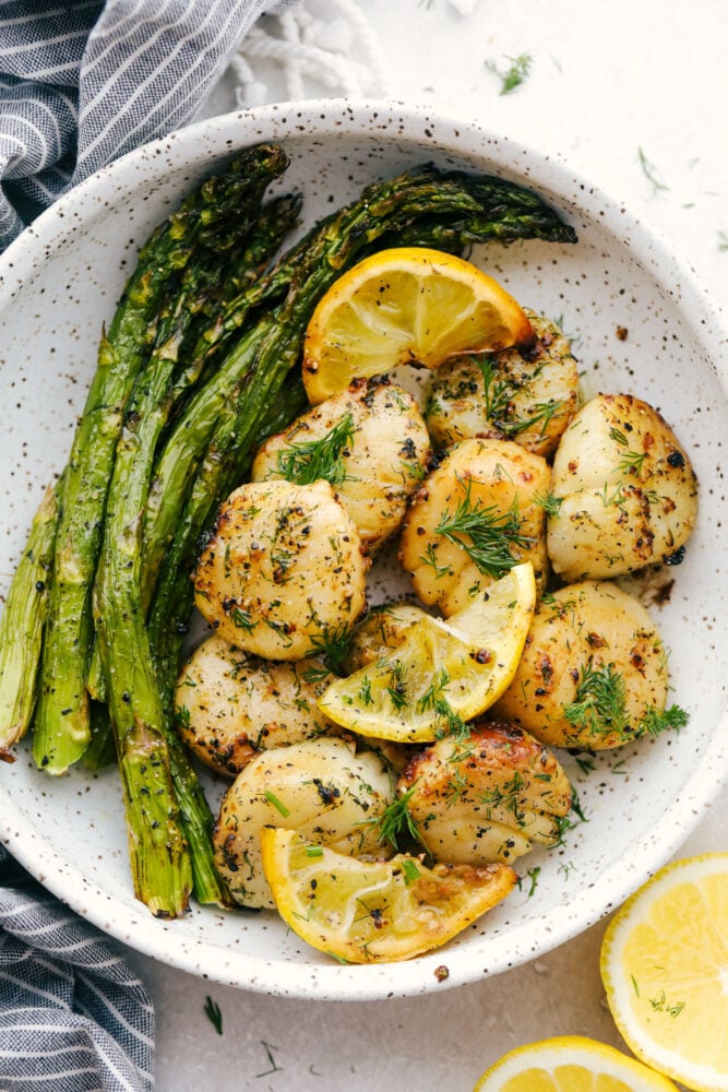 Air Fryer Lemon Dill Scallops are going to change the way you eat scallops! These are chock full of flavor, tender, juicy and succulent! Scallops with asparagus and lemons in a bowl.