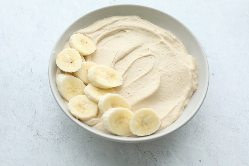 Peanut Butter Smoothie Bowl is one of the best ways to get your protein in for the day! It tastes like you are eating luscious ice cream, only it's so much better for you Smoothie in a bowl topped with bananas.