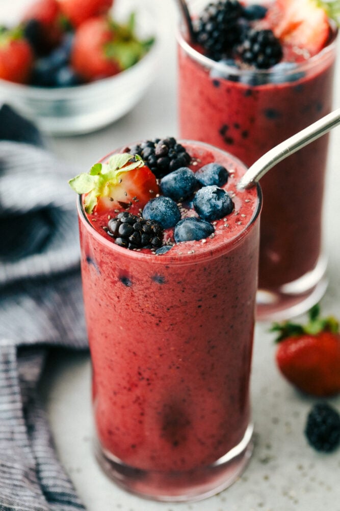Mixed Berry smoothie is the perfect answer to the need for a quick healthy breakfast or snack. Packed with flavorful fruit, protein-filled Greek yogurt and honey, it's a family pleaser for sure! Mixed Berry Smoothie topped with berries and chia seeds.