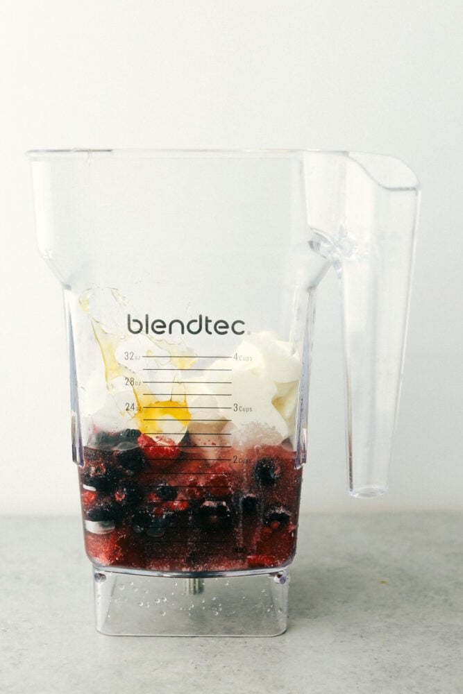 Mixed Berry smoothie is the perfect answer to the need for a quick healthy breakfast or snack. Packed with flavorful fruit, protein-filled Greek yogurt and honey, it's a family pleaser for sure! Ingredients in a blender ready to blend.