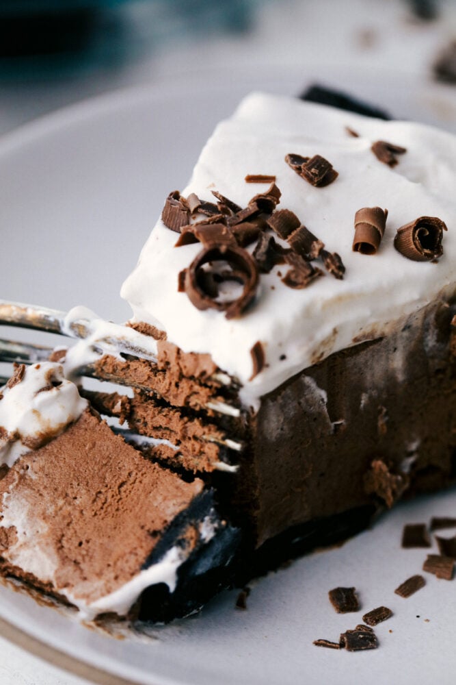 No Bake Chocolate pie is silky smooth, rich and incredibly indulgent! The perfect option when you want something exquisite, but don't want to heat up the kitchen! A fork cutting into a slice of chocolate pie.