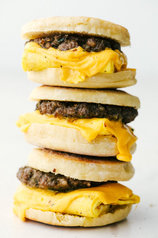 Homemade English Muffin Breakfast Sandwiches are the best thing to happen to your mornings! These are super easy, freezer friendly, and absolutely delicious! English muffin breakfast sandwiches stacked on top of each other.