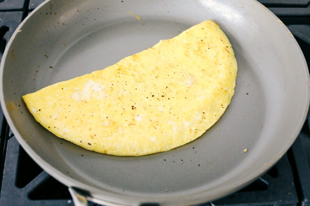 Homemade English Muffin Breakfast Sandwiches are the best thing to happen to your mornings! These are super easy, freezer friendly, and absolutely delicious! Cooked egg in a fry pan ready to use in sandwiches.