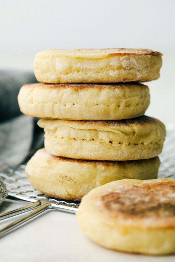 English Muffins are soft pillowy round morsels of absolute heaven. This is such an easy recipe you will be making them on a weekly basis! Stacked English muffins with the poke holes for easy cutting.