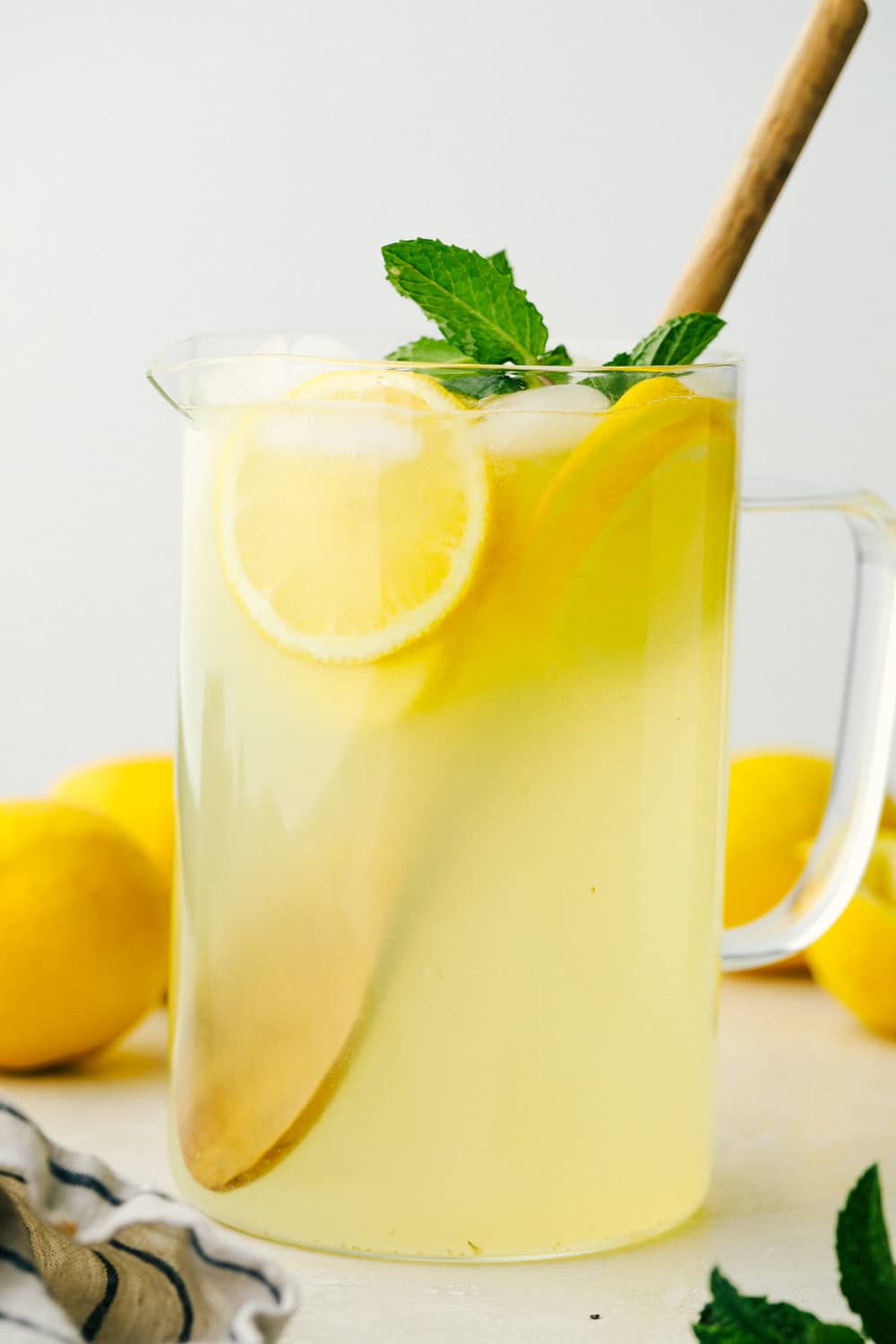 There isn't anything quite as refreshing as this Homemade Lemonade recipe, it's the BEST! Summer is going to be so cool, with a glass of this by your side. A pitcher of homemade lemonade with lemons.