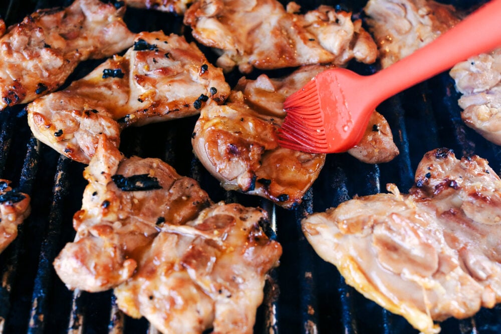 Grilled Huli Huli Chicken is a five star recipe! The marinade is quick and easy and full of such amazing flavor! You will make this again and again! Basting chicken as it grills.