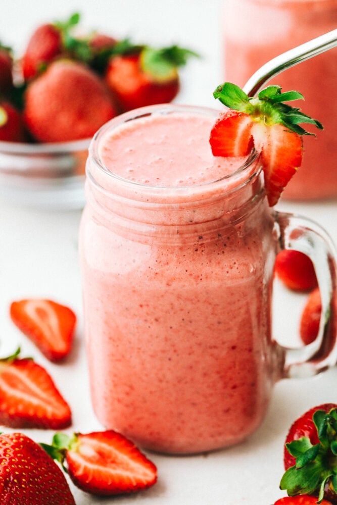 Strawberry Smoothie is creamy, refreshing, and the perfect way to satisfy your sweet tooth! It tastes just like a milkshake, but more nutritious! Strawberry smoothie in a glass mason jar with a metal straw.