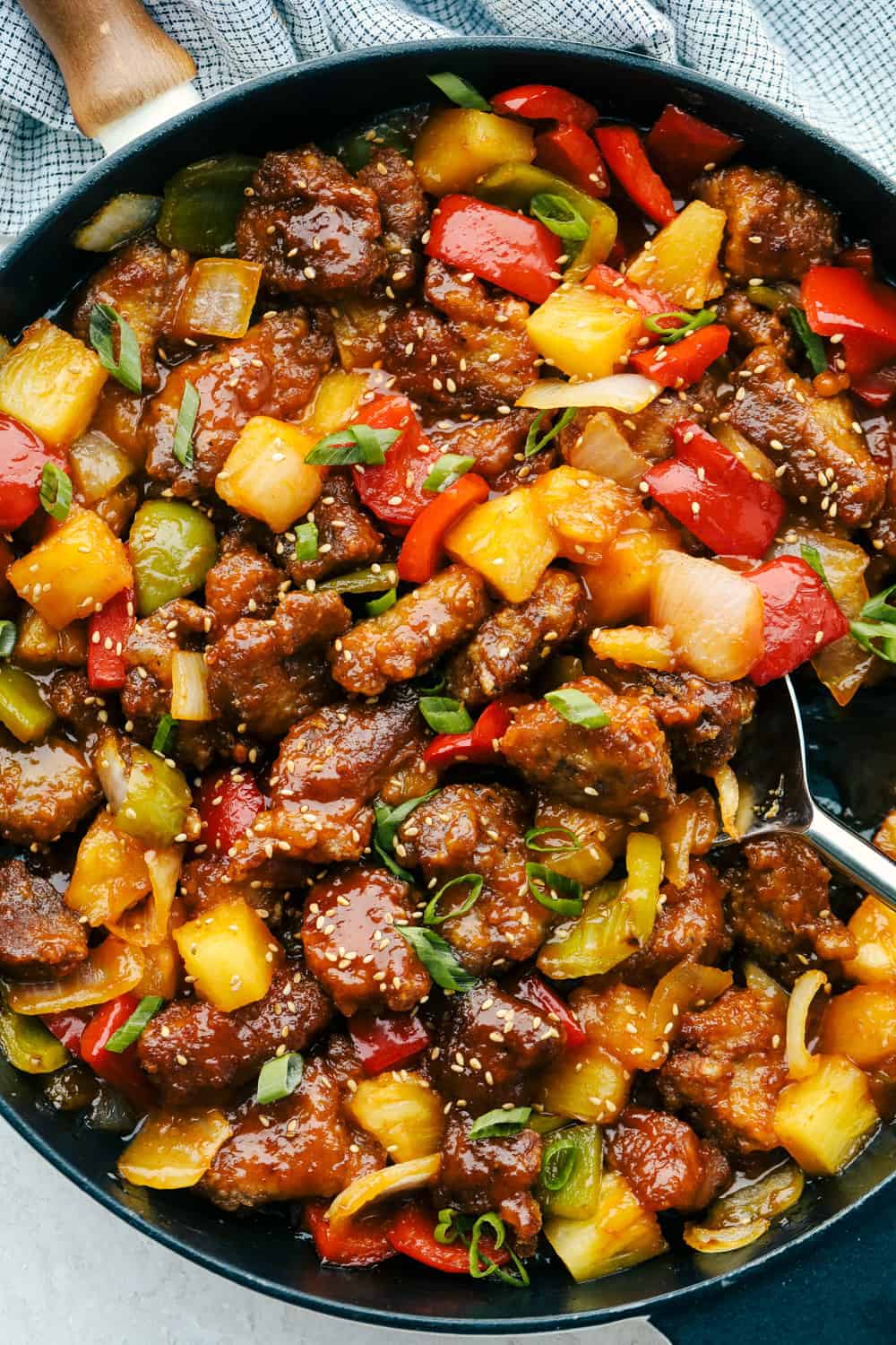 This sensational Sweet and Sour Pork is everything you want in take out, only better!ย You are going to love the succulent pork combined with the most incredible sauce! A pan of sweet and sour pork with seeds ready to be served.