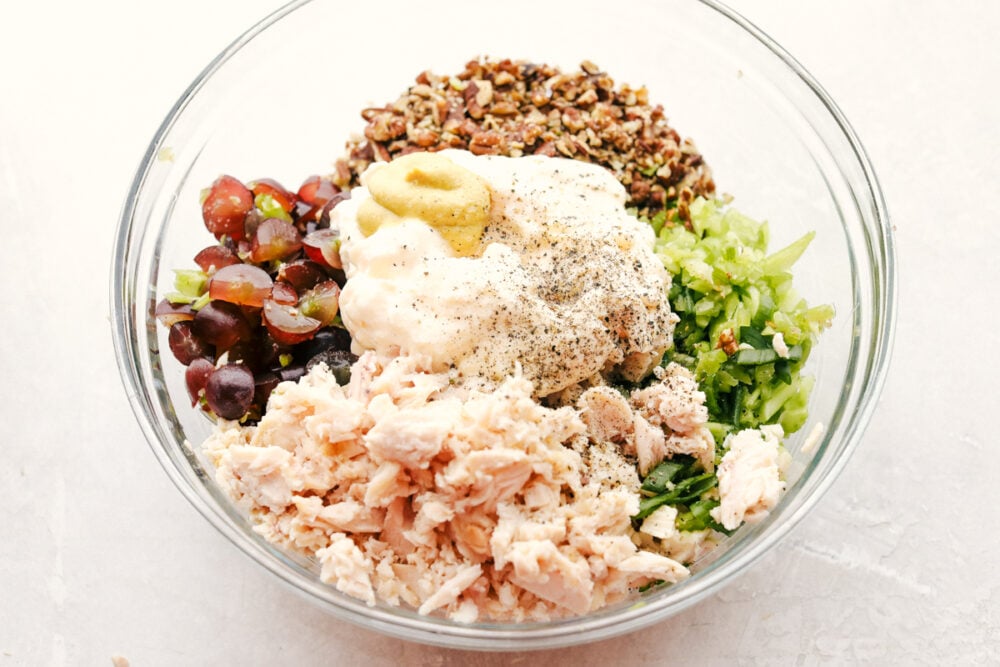 This is the Best Chicken Salad EVER! Perfect for summer picnics, festive lunches and anytime in between! All the ingredients with the dressing ingredients in a bowl ready to stir.