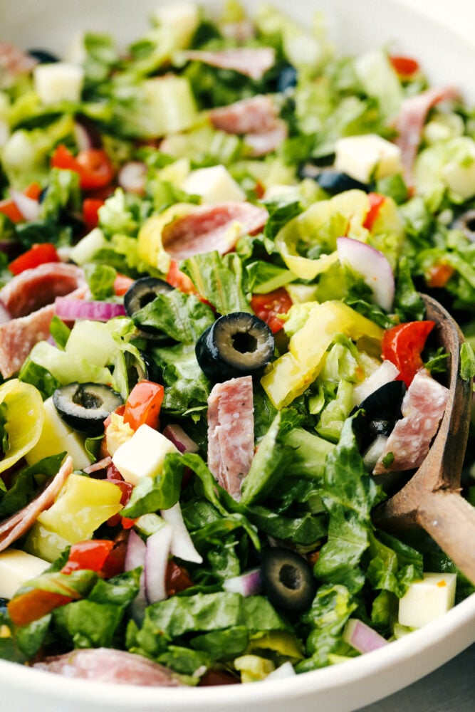 Italian Chopped Salad is stuffed with flavor and texture that is highly satisfying. Full of classic Italian flavors, this salad is going to be a huge hit at your next gathering! Mixed Italian chopped salad ready to serve.