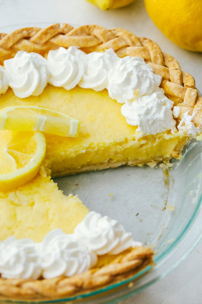 Lemon Pie is sweet, but a bit tart and totally refreshing! The perfect zingy, light, summertime dessert! A slice missing from a fresh lemon pie.