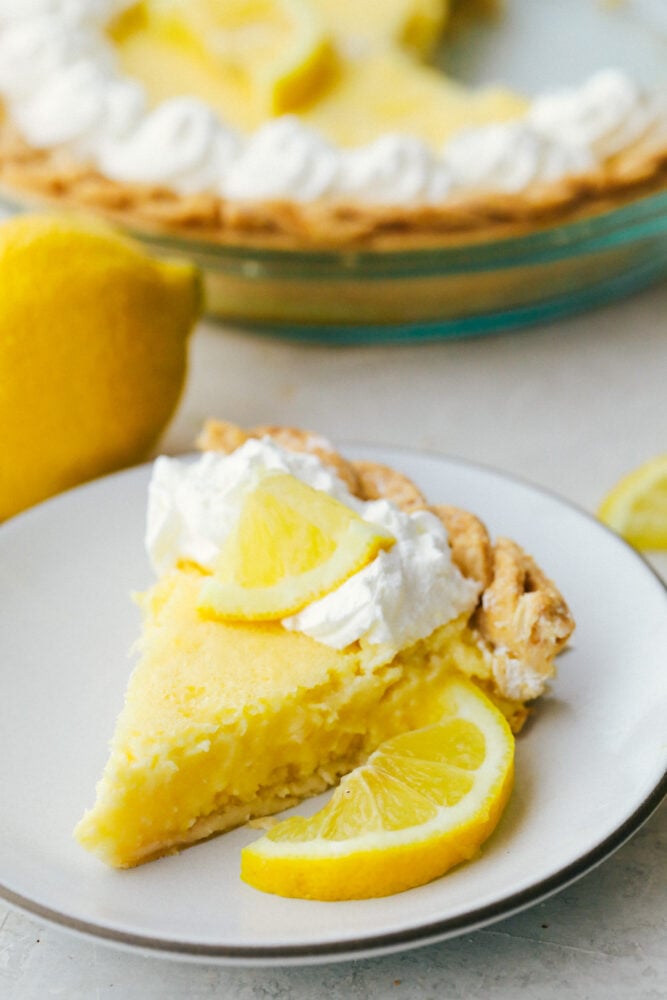 Lemon Pie is sweet, but a bit tart and totally refreshing! The perfect zingy, light, summertime dessert! A slice of lemon pie on a plate.