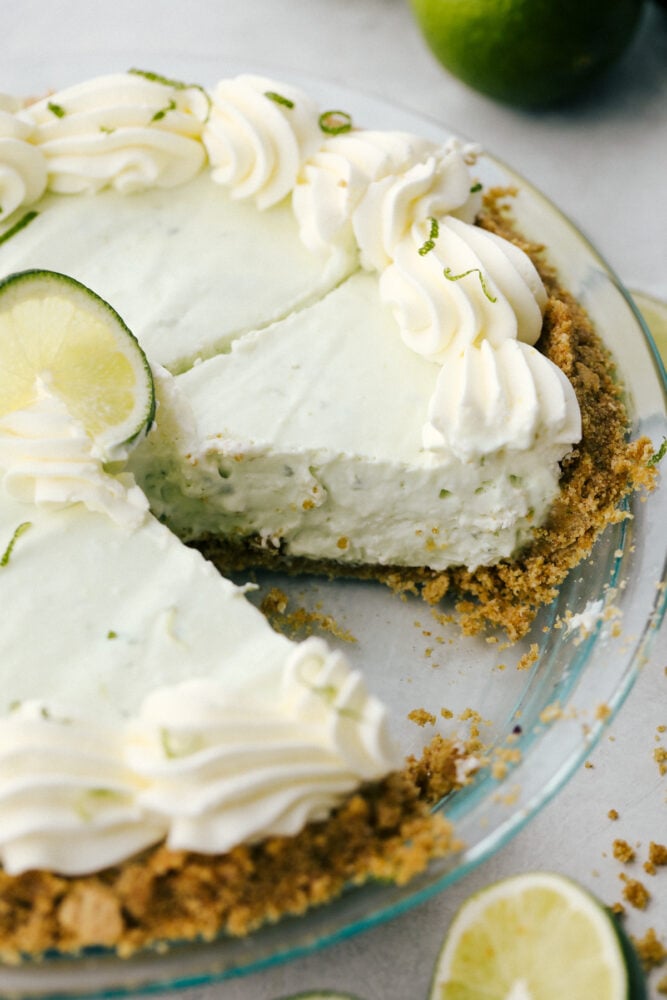 No Bake Key Lime PIe is a slice of tropical heaven. This has a sweet crunchy crust filled with a refreshing, creamy and zippy lime filling perfect for the summer heat! The no-bake key lime pie with a piece missing.