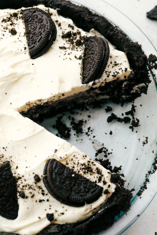 This No-Bake Oreo Pie is going to steal the show! It's so quick and easy you might find yourself making it everyday! No-bake oreo pie with a slice missing.