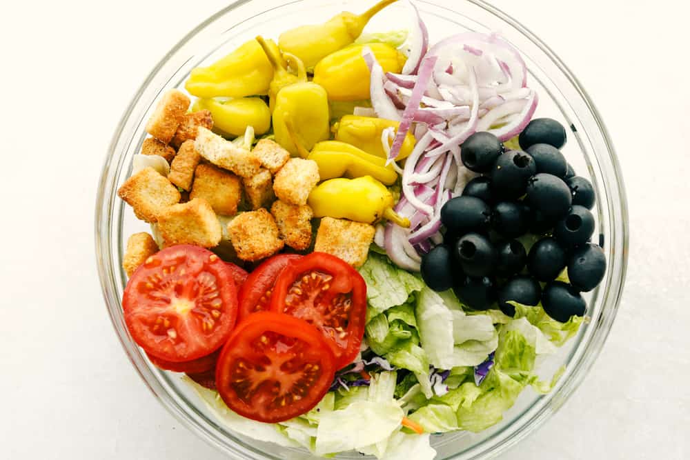 Copycat Olive Garden Salad is one of my all-time favorite restaurant salads, and now you can make it right at home. Itโs bright, zesty, and packed with that fresh, irresistible flavor everyone loves. All of the ingredients added to a big bowl.