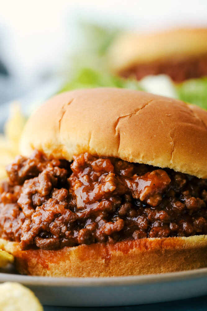 Delicious Sloppy Joes are messy, saucy and the perfect family dinner. A timeless classic, these are bound to be the best you have ever had! Upclose picture of a sloppy joe on a plate.