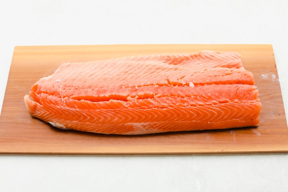 Smoky, woodsy flavors meet summery honey and lime in this melt-in-your-mouth salmon recipe! You are not going to be able to get enough of this irresistible Cedar Plank Honey Lime Salmon! A fresh cut of salmon on cedar plank.