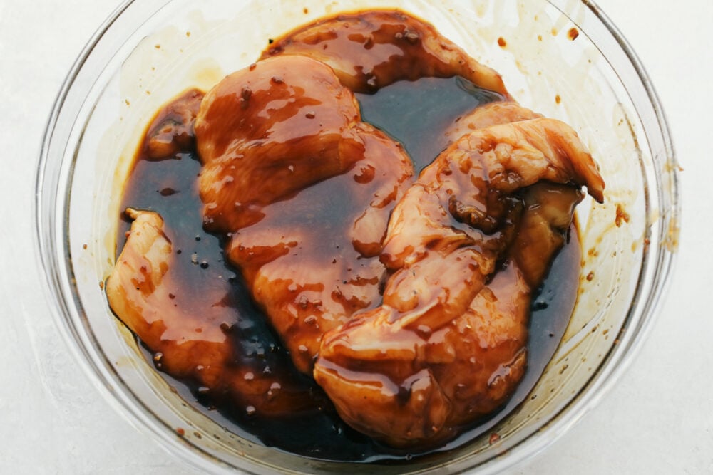 Grilled Teriyaki Chicken is the ultimate quick and easy, absolutely delicious dinner! Tender juicy chicken is soaked in the BEST Teriyaki Sauce then grilled to perfection Raw chicken marinating in the teriyaki sauce.