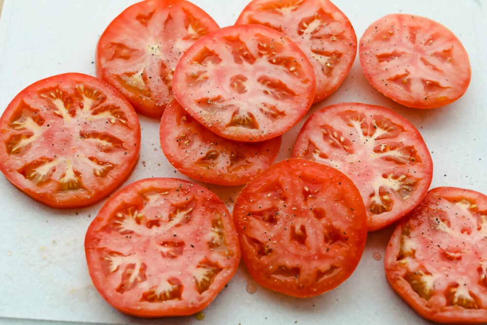 Super easy and super delicious, you are going to love these juicy Grilled Tomatoes! Each slice is cooked to perfection and bursting with luscious, savory flavors in every bite. Raw tomatoes salted and peppered