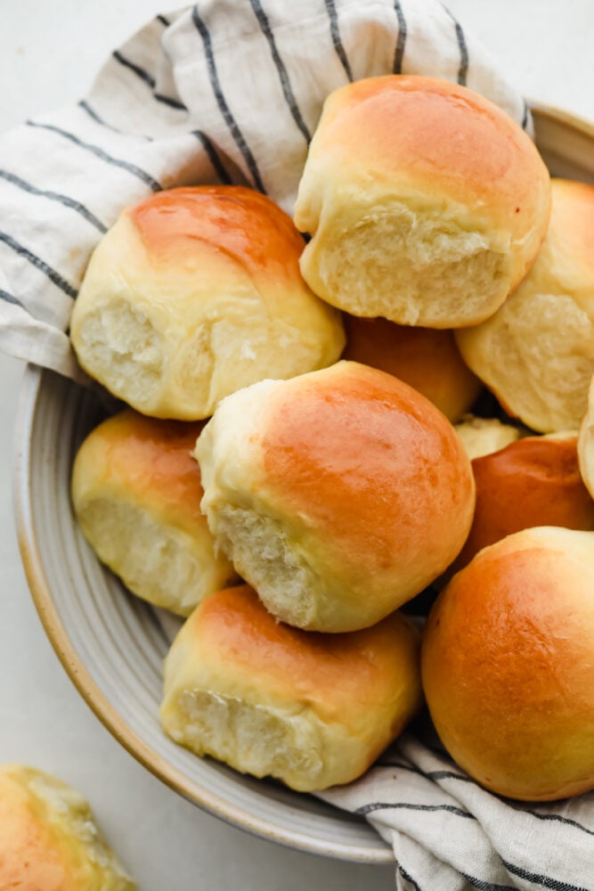 Moist, fluffy Hawaiian Sweet Rolls are a staple you will want to use for all your weekday meals. Whether you use them for sliders, sides, or just eat them as-is like me, they will be gone in no time with how sweet and buttery-soft they are! Hawaiian Rolls in a bowl.