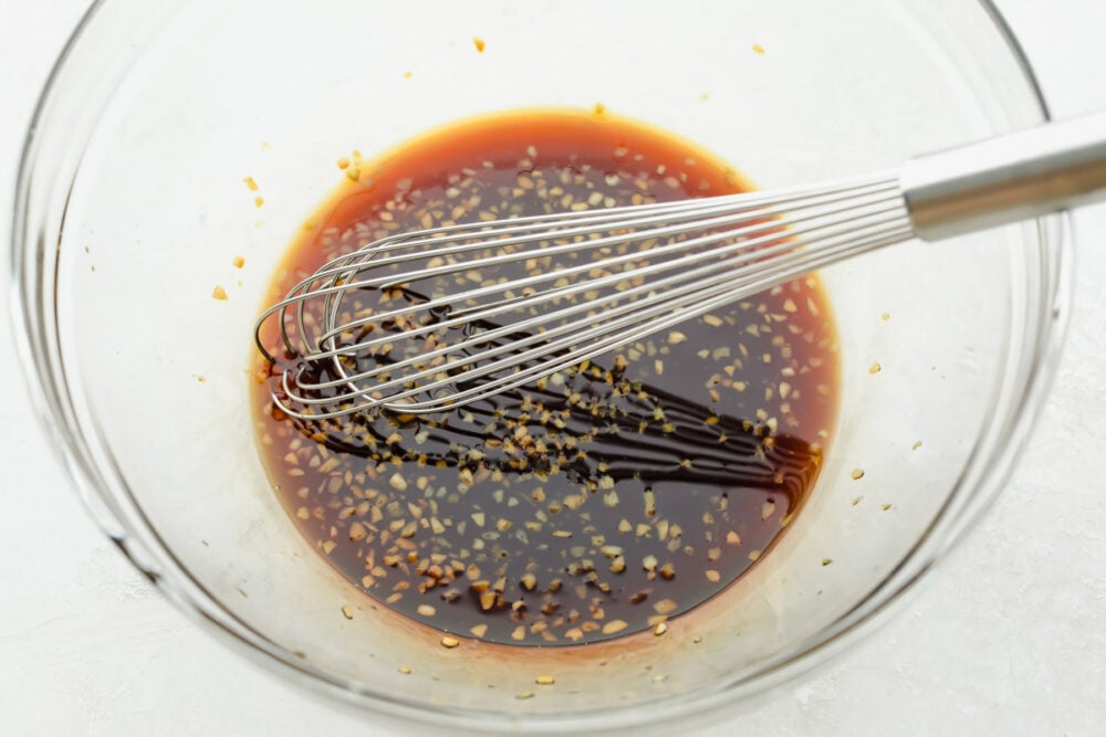 This Grilled Honey Garlic Chicken is healthy and delicious with a sweet, sticky garlic glaze. It only takes 5 ingredients to make the marinade and cooks up in less than 10 minutes. Whisking together marinade.