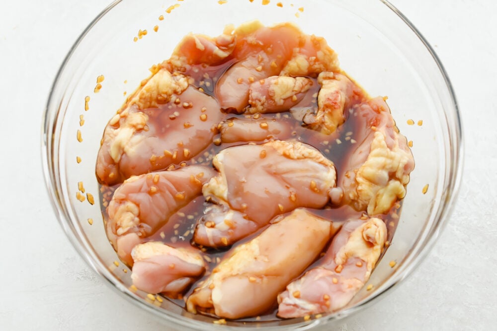 This Grilled Honey Garlic Chicken is healthy and delicious with a sweet, sticky garlic glaze. It only takes 5 ingredients to make the marinade and cooks up in less than 10 minutes. Chicken soaking in marinade.