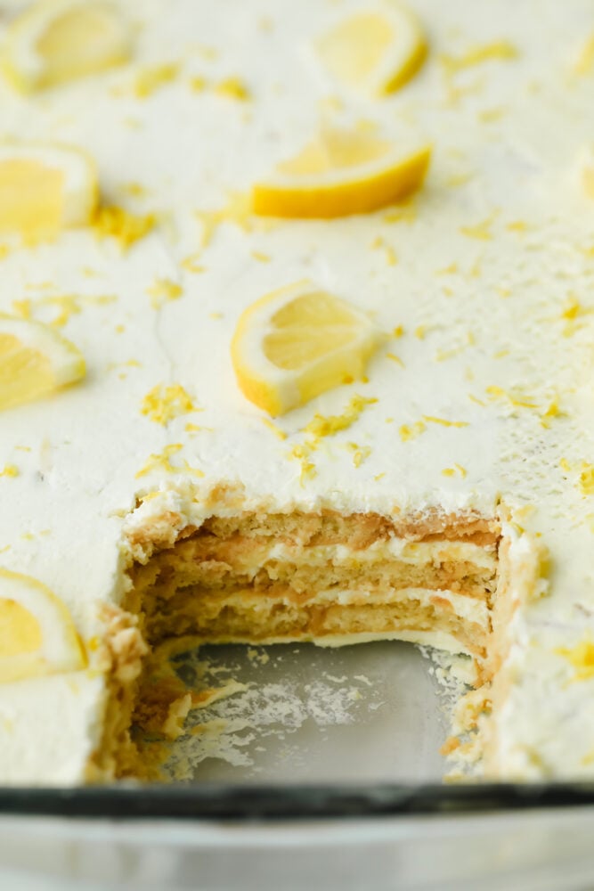 Layers of buttery shortbread and lemon cream come together in this scrumptious no-bake summer dessert! Not only is this recipe beyond easy, but has the perfect balance of tart and sweet flavors! Piece taken out of Lemon Icebox Cake.