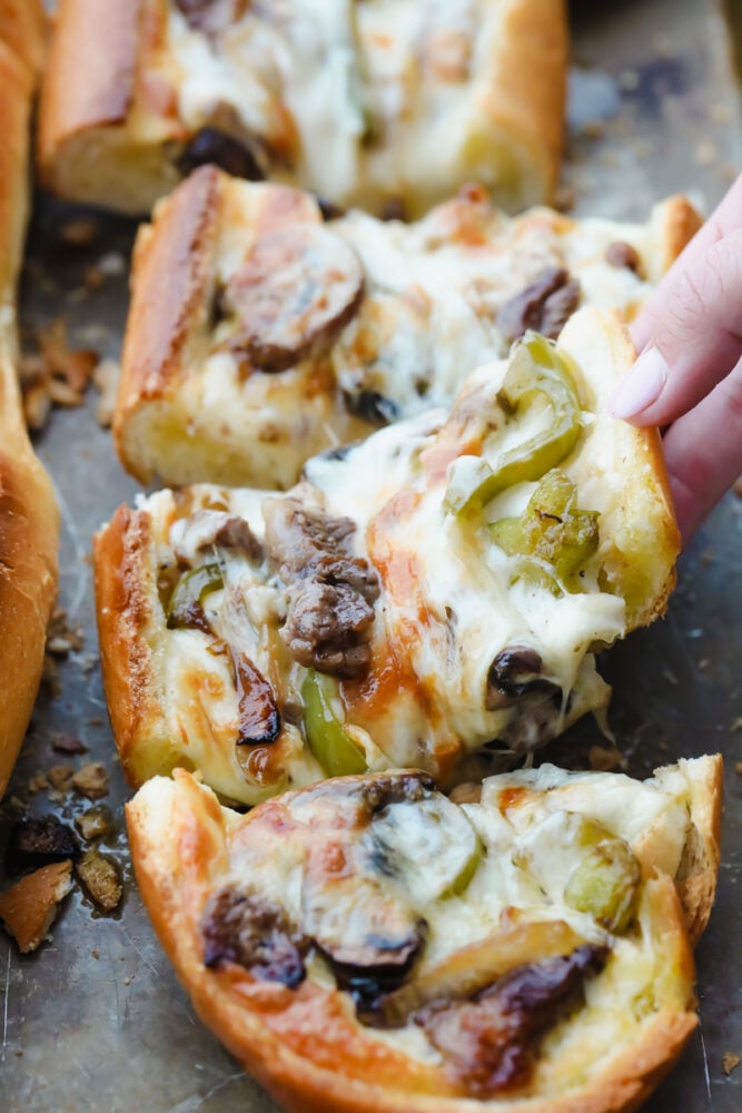 Philly Cheese Steak Cheesy Bread with just a few simple ingredients is the taste of Philly for a crowd! It comes together in just minutes with major flavor in each bite! Picking up a piece of Philly cheesesteak cheesy bread