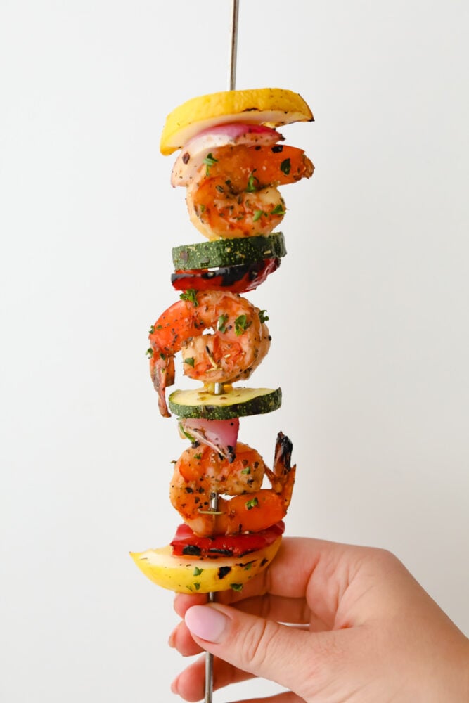 Shrimp Kabobs are marinated and grilled to perfection for the most scrumptious summer meal. Full of zesty flavors the whole family is going to love these kabobs! Seasoned and grilled kabob ready to eat.