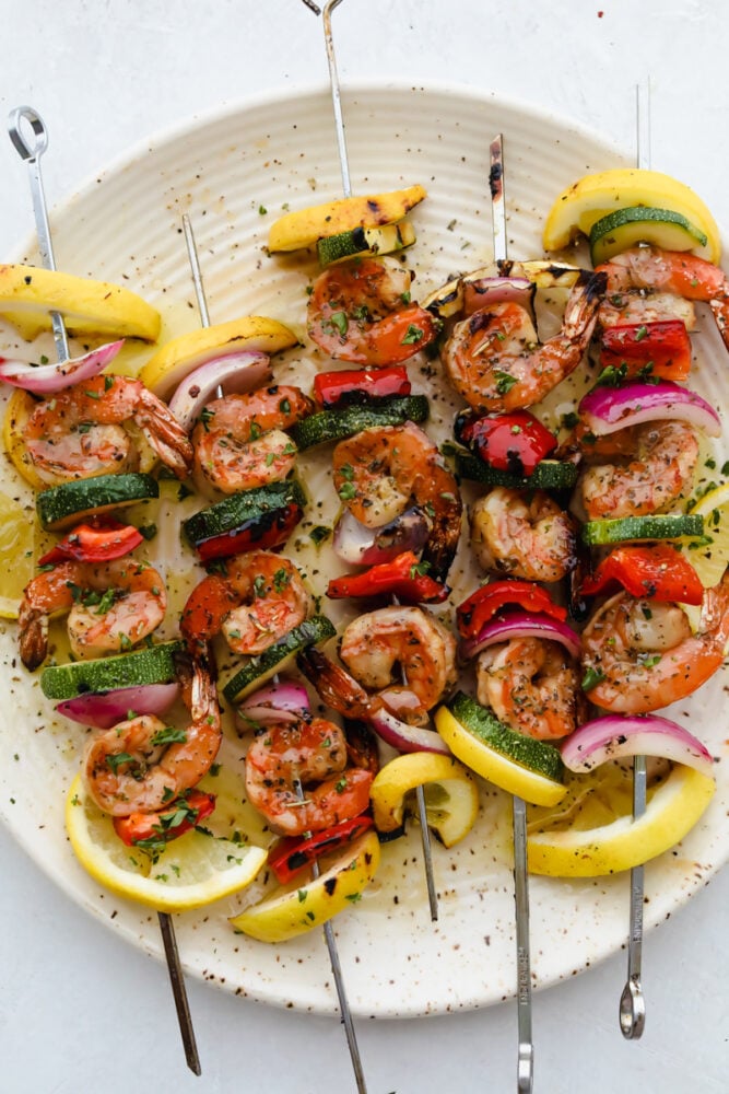Layer this amazing marinade onto your shrimp for a perfectly rich, savory flavor with a pop of lemon your taste buds will LOVE! The drool-worthy flavor combinations and ease of preparation make this Shrimp Marinade a recipe to come back to over and over again. Grilled marinated shrimp on skewer with veggies.
