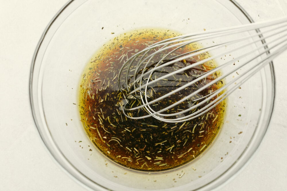 Layer this amazing marinade onto your shrimp for a perfectly rich, savory flavor with a pop of lemon your taste buds will LOVE! The drool-worthy flavor combinations and ease of preparation make this Shrimp Marinade a recipe to come back to over and over again. Whisking marinade ingredients together.