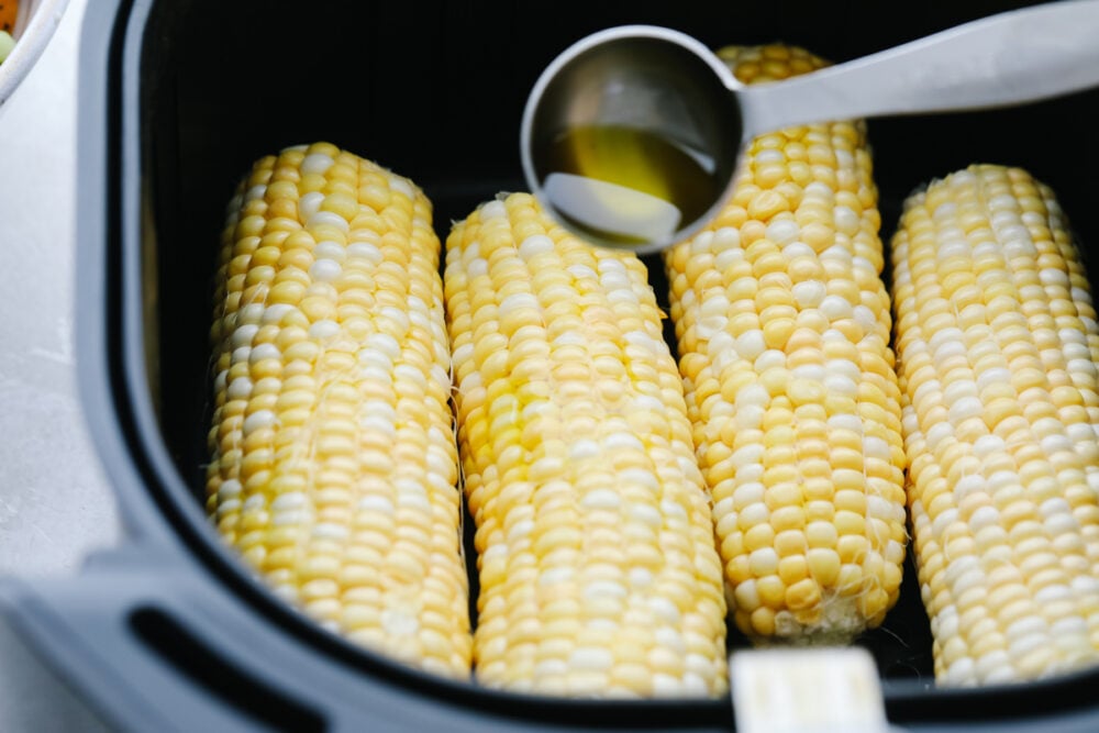 Air Fryer Corn on the Cob is going to change the way you cook corn. Super fast, tender, and full of flavor air fryer corn is insanely delicious. Drizzling the corn with olive oil before air frying.