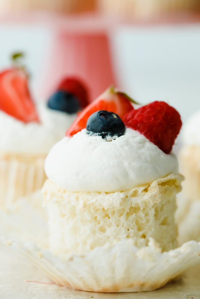 These ultra-fluffy, delicate cupcakes are the best base for light and tasty summer treats. Top with fresh whipped cream frosting and berries for a dessert that is a perfect combination of airy and sweet. Close-up of an Angel Food Cupcake.