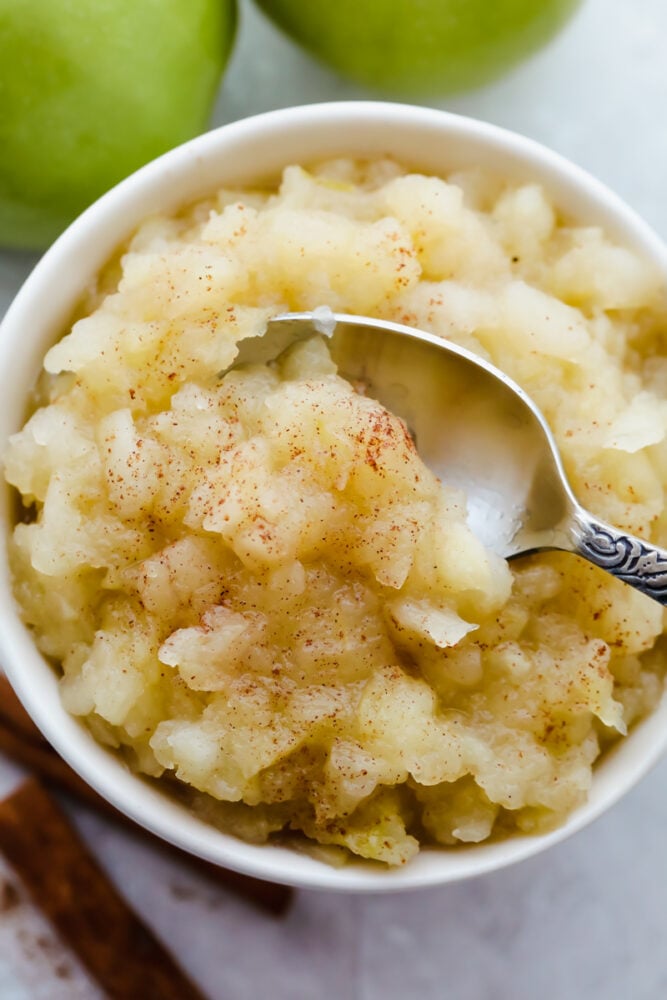 I love homemade applesauce! It is such a simple way to incorporate all of the apples that I have in my fridge! PLUS as a bonus, my kids are more inclined to eat something so simple! Finished homemade applesauce with spoon, ready to eat.