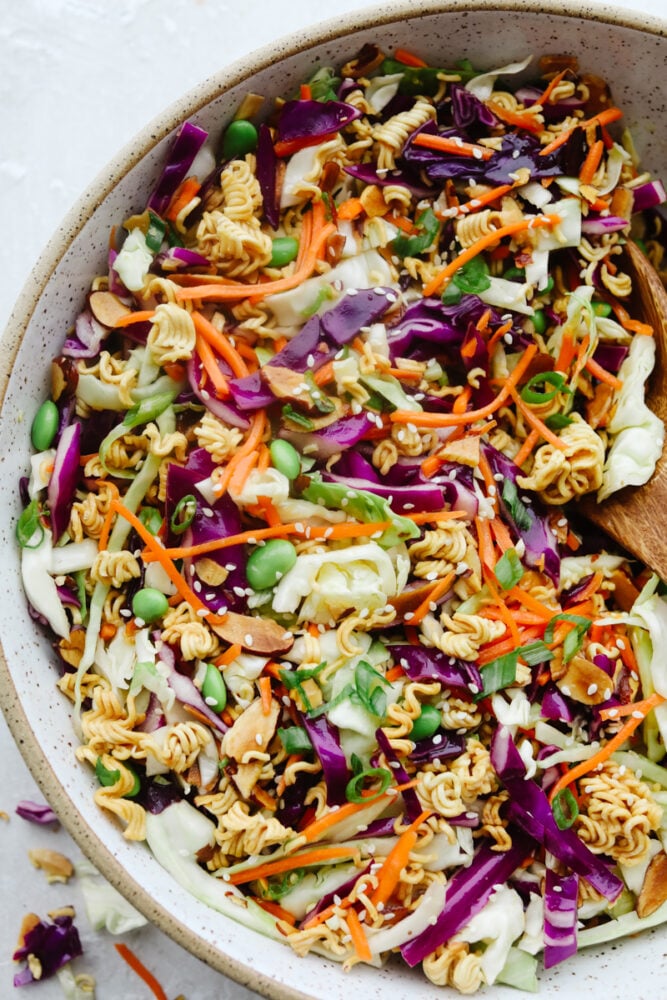 Asian Ramen Salad is full of color, flavor, and crunch! All of the fun textures make it perfectly satisfying and insanely delicious! A bowl of colorful Asian Ramen salad.