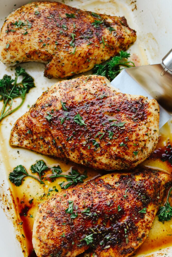 This perfect and juicy baked chicken will be sure to get a WOW at your next family get-together! It is seasoned with a delightful array of spices and baked to perfection! Your tastebuds will thank you later!! Baked chicken being served from a platter.