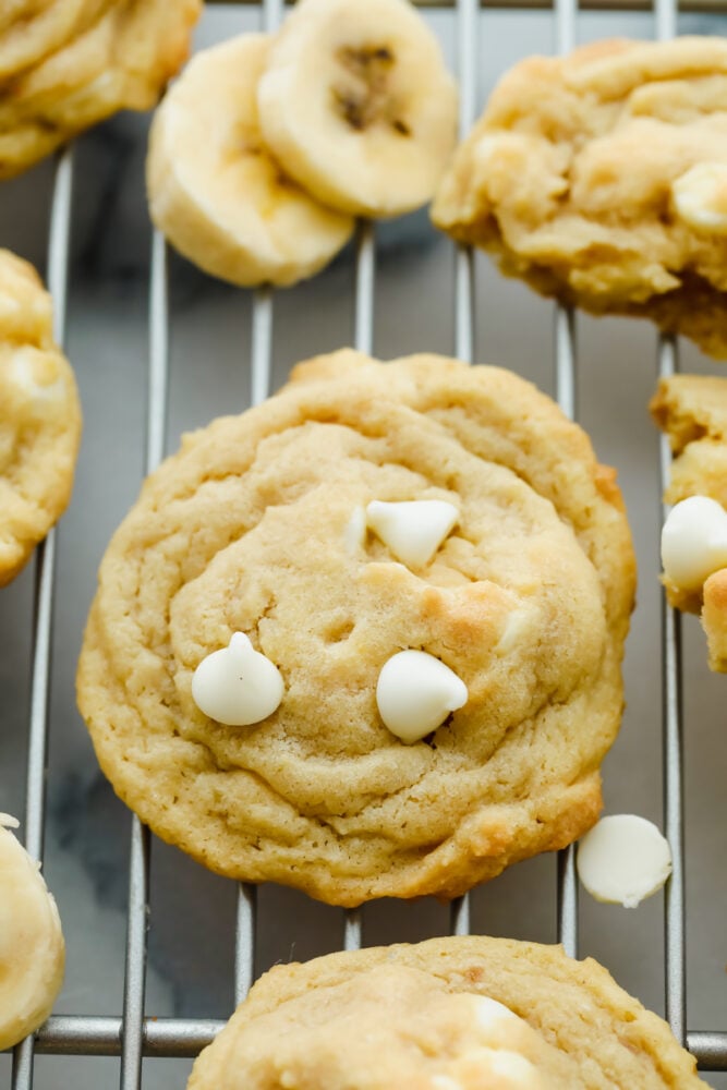 Banana Pudding Cookies are soft, chewy, and absolutely scrumptious. With all the banana flavor of a banana cream pie wrapped in a cookie. Banana cookies on a wire rack.