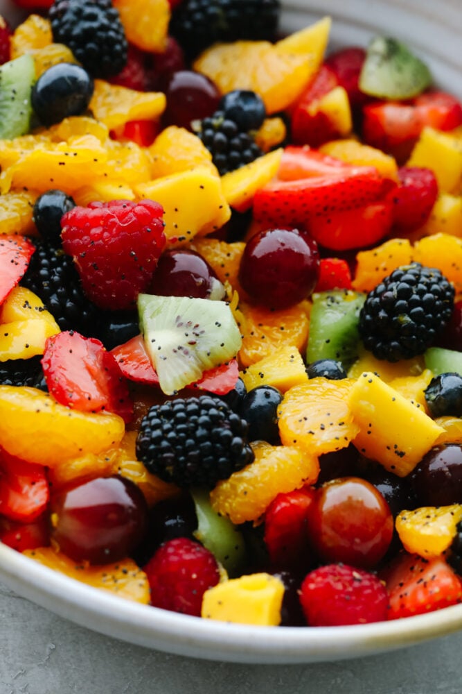 Blackberry Lime Fruit Salad showcases tons of fresh, summer fruit and has a delicious easy dressing. Refreshing, light, and sweet, this fruit salad will be eaten in no time! Blackberry Lime Fruit Salad with poppyseed dressing in bowl.