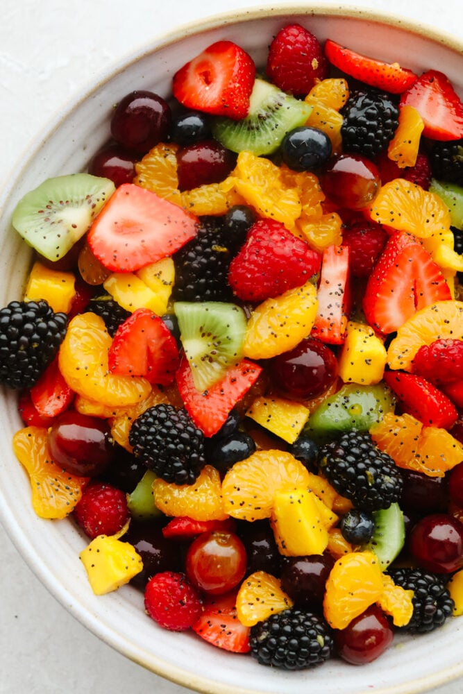 Blackberry Lime Fruit Salad showcases tons of fresh, summer fruit and has a delicious easy dressing. Refreshing, light, and sweet, this fruit salad will be eaten in no time! Mixed summer fruits with poppyseed dressing in bowl.