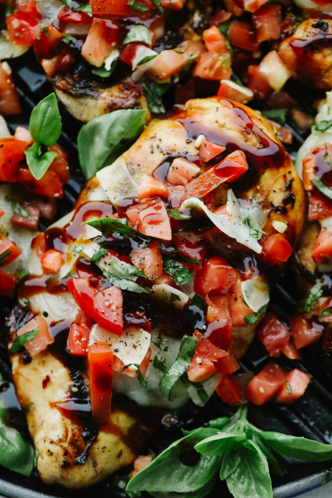 Bruschetta Chicken is a delicious, low-carb meal that packs big, mouthwatering flavor. With fresh vegetables, garlic, a sticky-sweet balsamic glaze, and homemade Italian Seasoning, this will be your new go-to lunch. Close-up of Bruschetta Chicken and toppings.