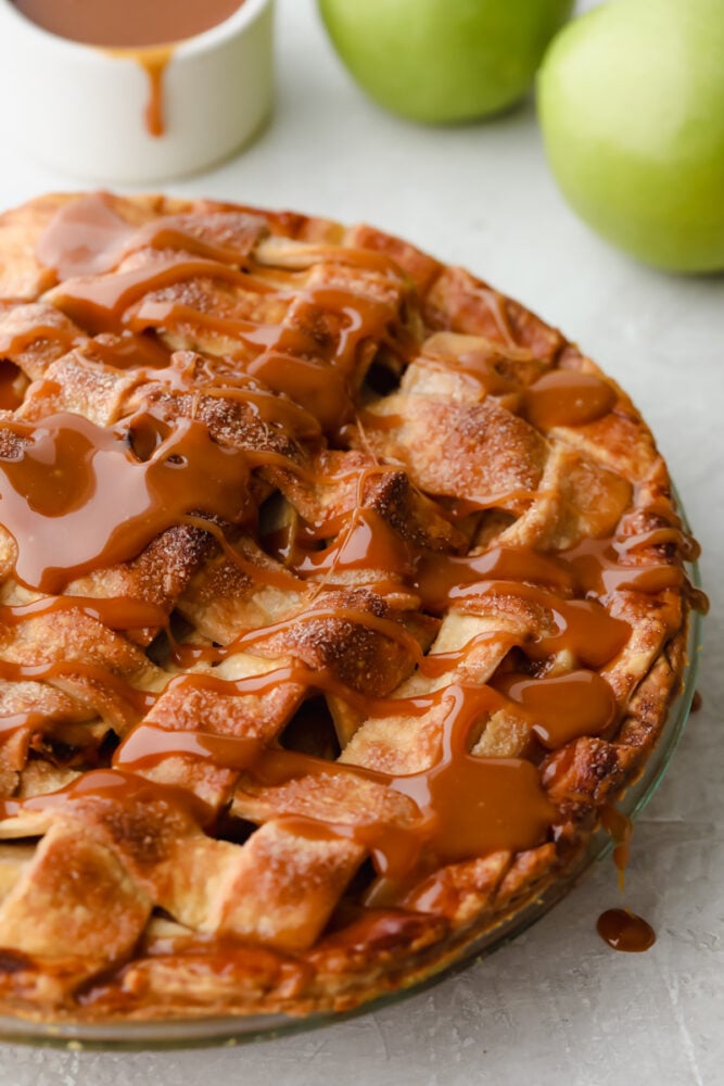 Caramel Apple Pie is the traditional American dessert, but totally elevated. Sour tart apples are smothered in caramel, it's insanely delicious. Caramel apple pie with caramel drizzled on top.